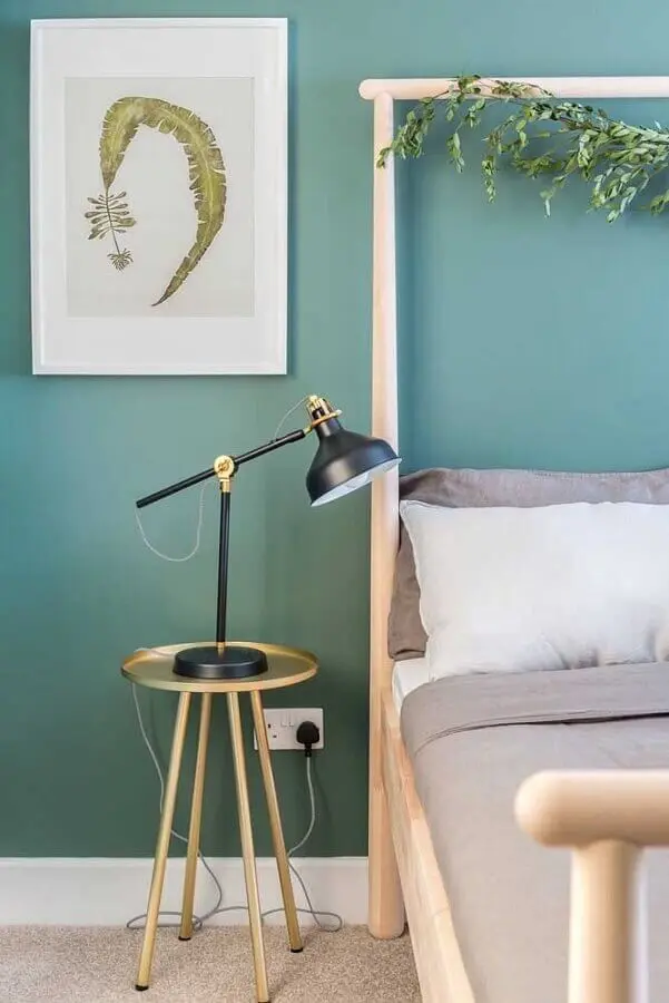 Parede cor verde água para decoração de quarto com mesa lateral redonda