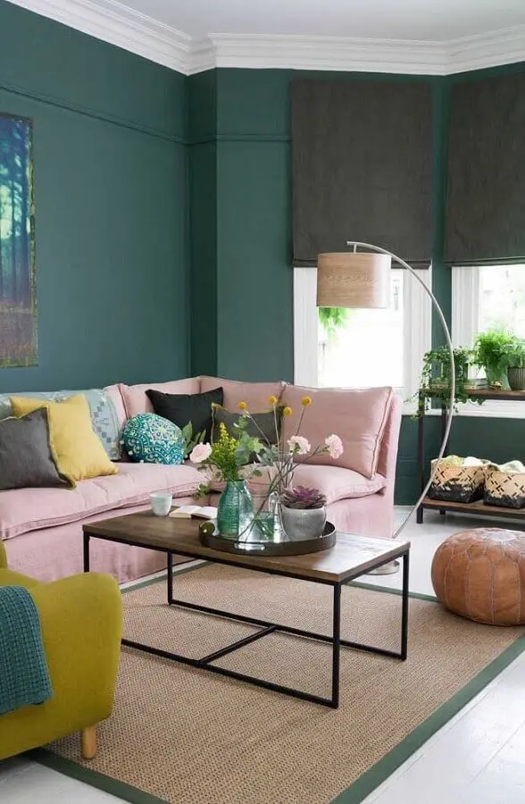 Parede na cor verde escuro para sala decorada com sofá rosa e luminária de chão