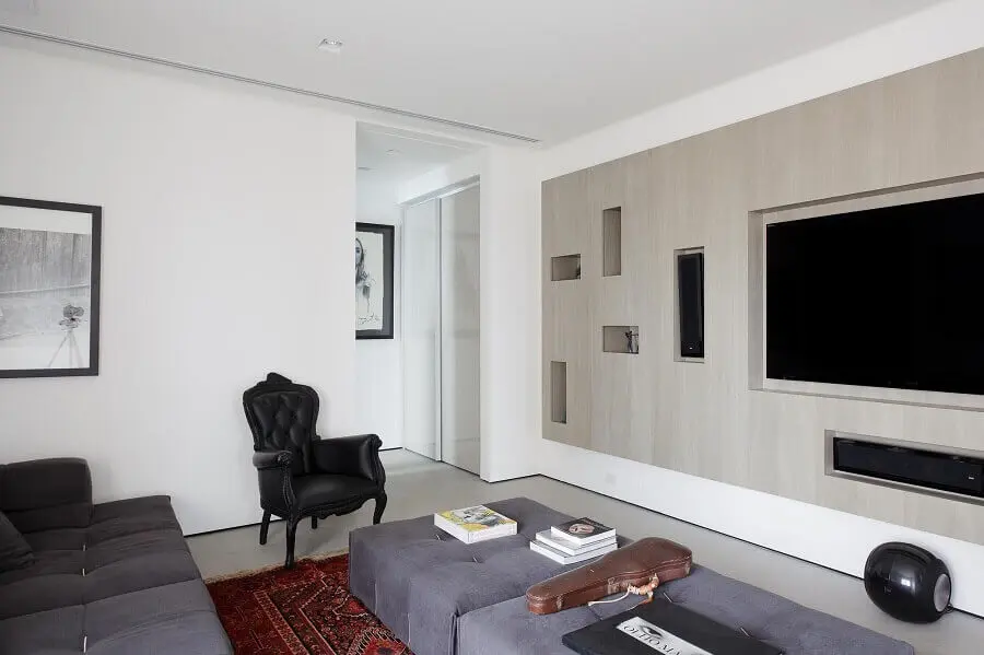 Poltrona preta clássica para decoração de sala de TV com sofá e puff grande cinza