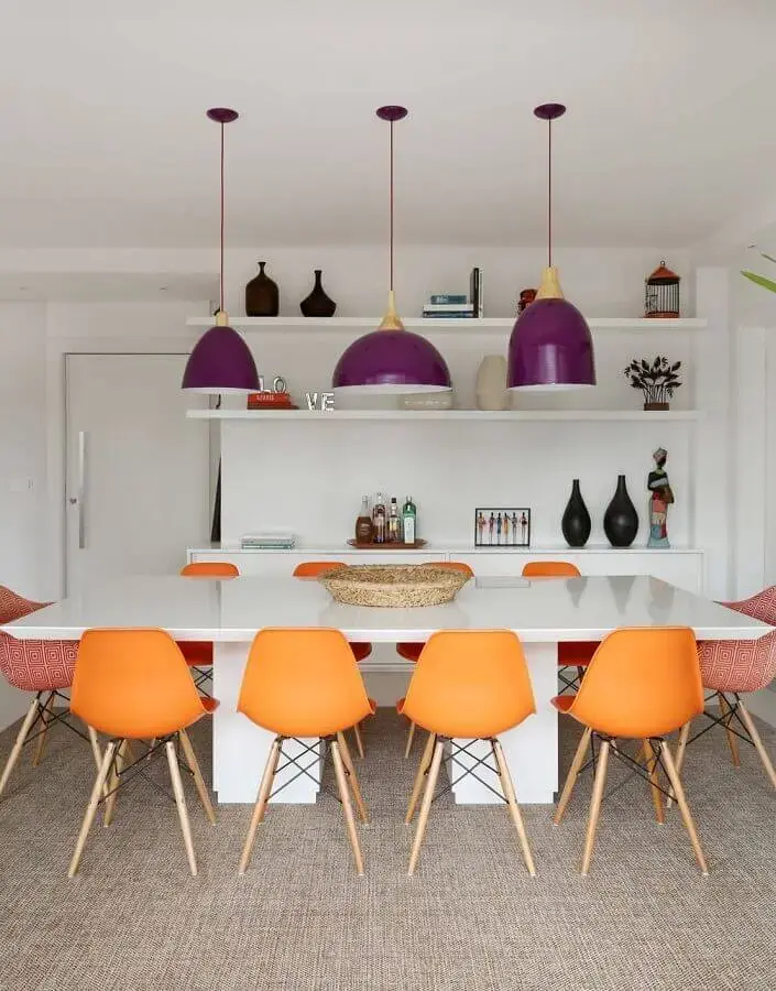 sala branca decorada com luminárias grandes e cadeiras coloridas para mesa de jantar Foto Histórias de Casa