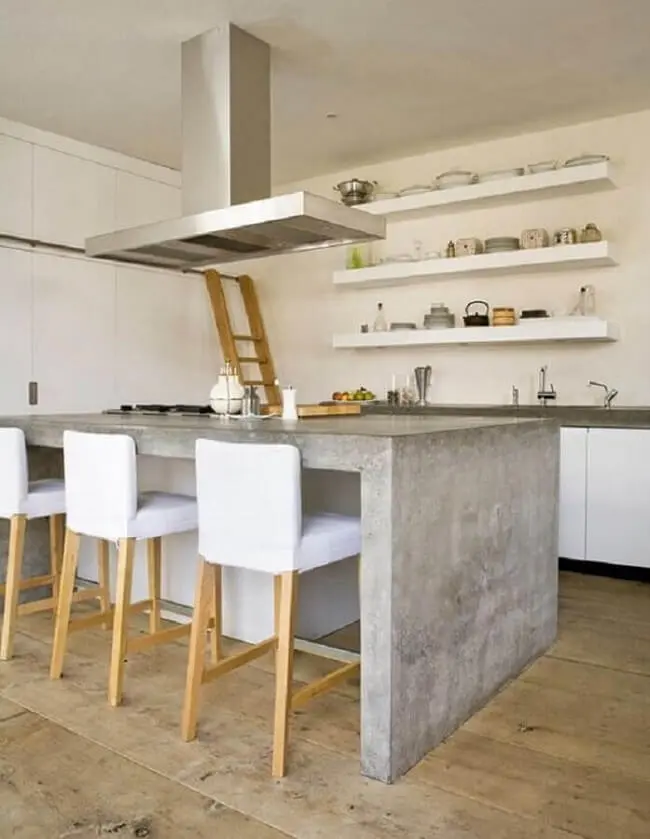 Bancada de cozinha de cimento queimado e prateleiras brancas decoram o ambiente. Fonte: Você Precisa Decor