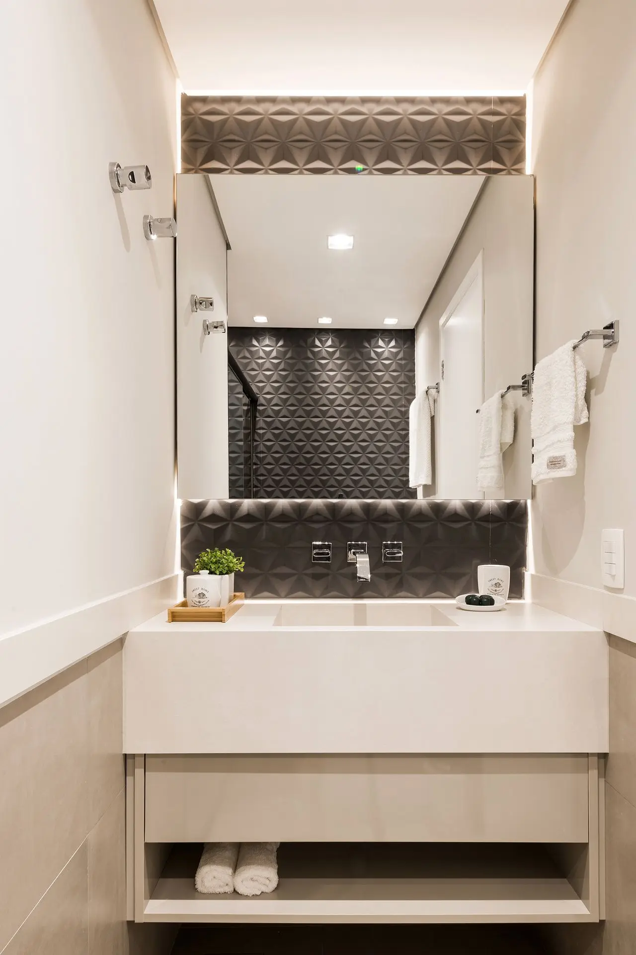 Banheiro com azulejo 3D preto e armário branco