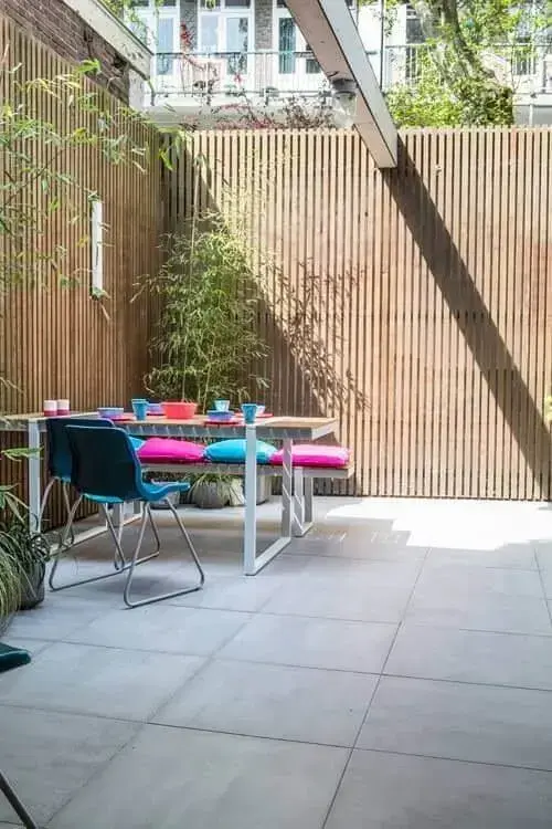 Quintal com mesa e cadeiras colorida e decorado com plantas