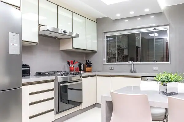 Cozinha clean com armários brancos e bancada em silestone cinza claro