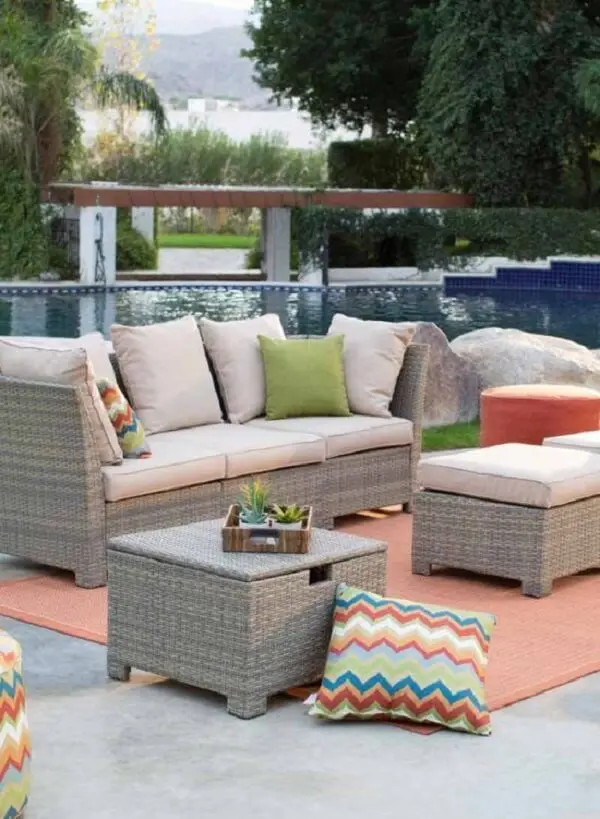 Crie um espaço confortável com sofá de vime próximo a área da piscina
