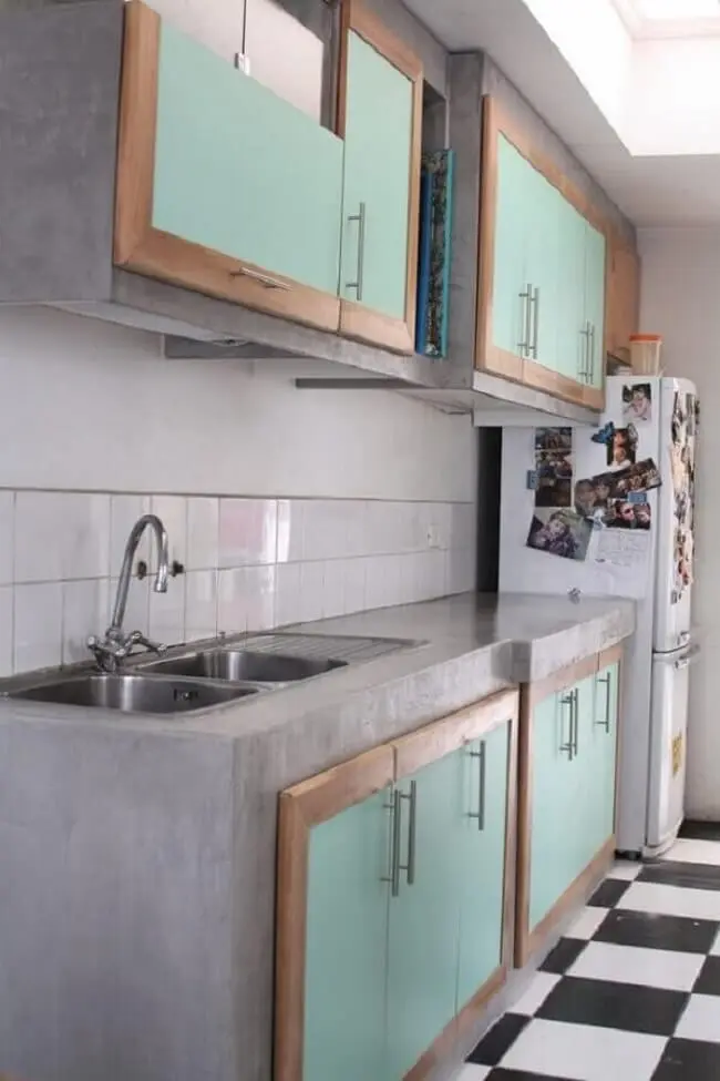 Decoração simples com bancada de cozinha de cimento queimado e armários com portas verdes. Fonte: Arquidicas