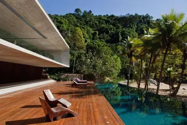 Móveis para piscina com deck de madeira na mansão moderna