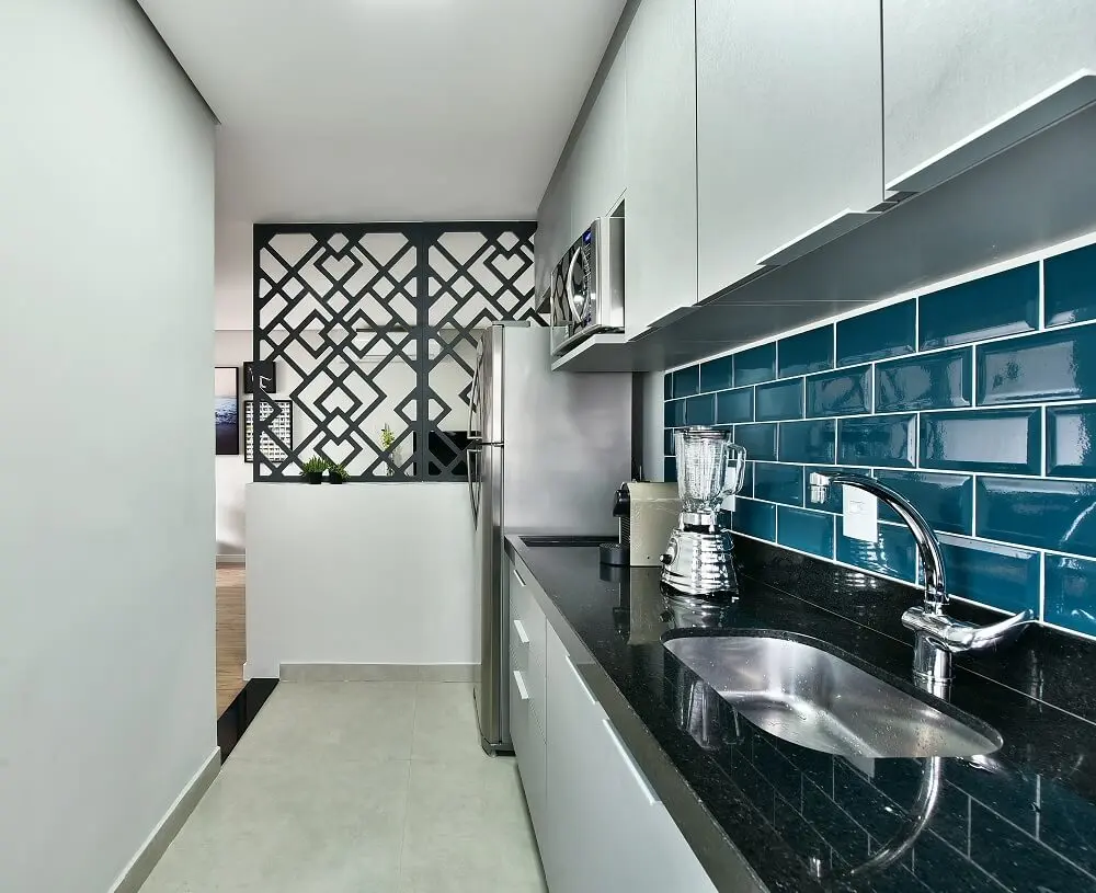 O revestimento colorido em tom azul, agrega valor na estética da cozinha e protege a parede de gorduras e respingos de água e sabão. Foto: Sidney Doll