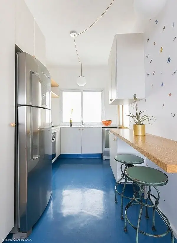 Piso colorido cozinha azul, armários brancos e bancada de madeira formam uma linda composição