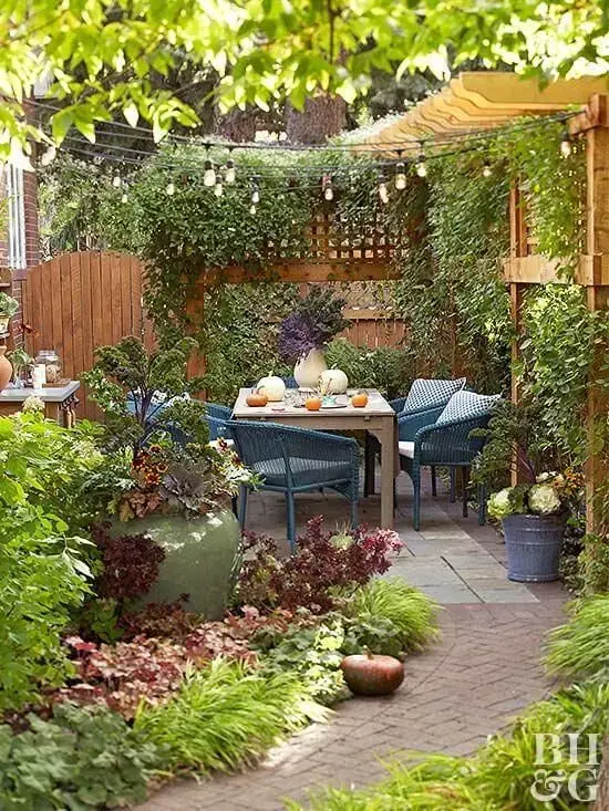 Quintal pequeno decorado com plantas e mesa para área externa