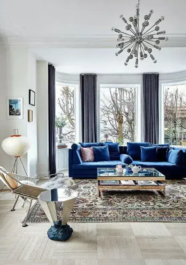 Sala ampla com sofá azul marinho e cortina da mesma cor