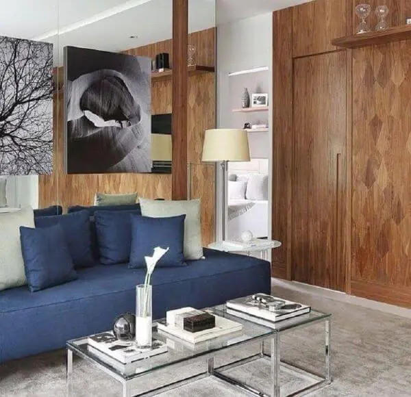Sala chique com revestimento de madeira e sofá azul marinho