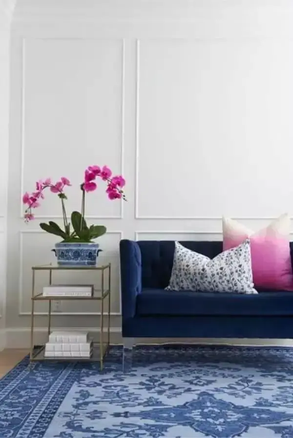 Sala cinza com sofá azul marinho e almofadas decorativas rosa