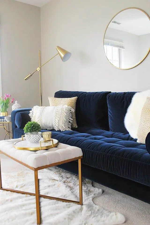 Sala clara com sofá azul marinho em destaque