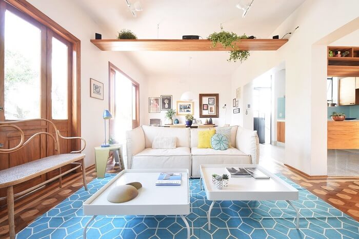 Sala com sofá branco e tapete azul estampado