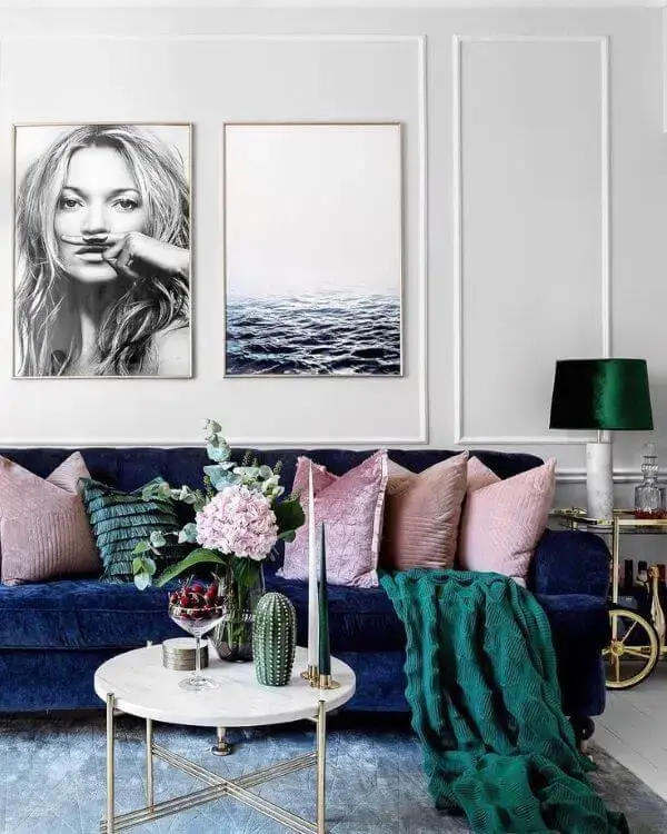 Sala com sofá azul marinho almofadas e rose e manta