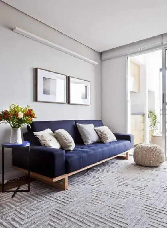 Sala minimalista com sofá azul marinho