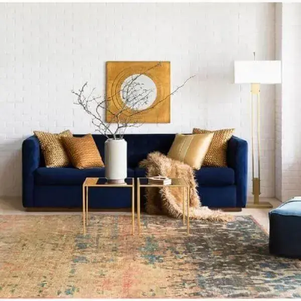 Sala moderna com sofá azul marinho e enfeites dourados