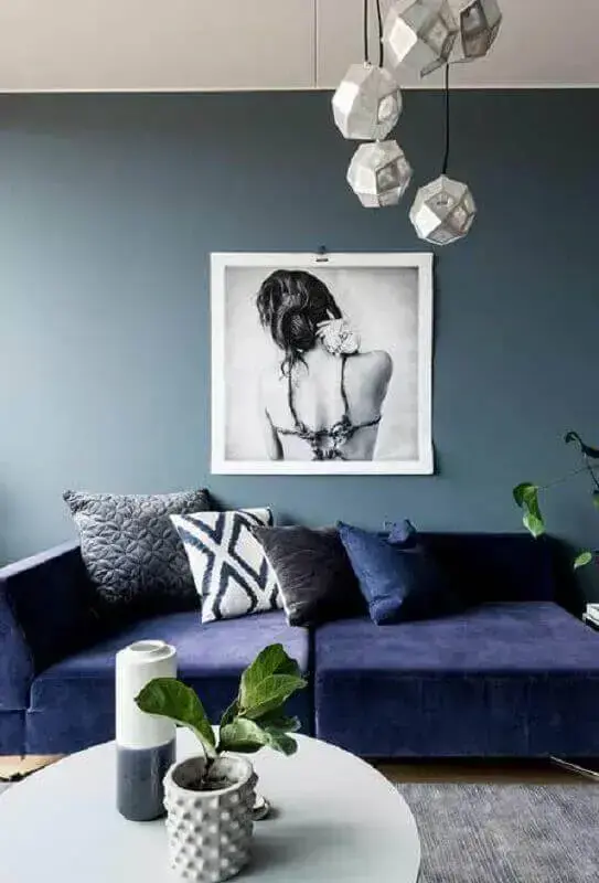 Sala moderna com sofá azul marinho e parede azul claro