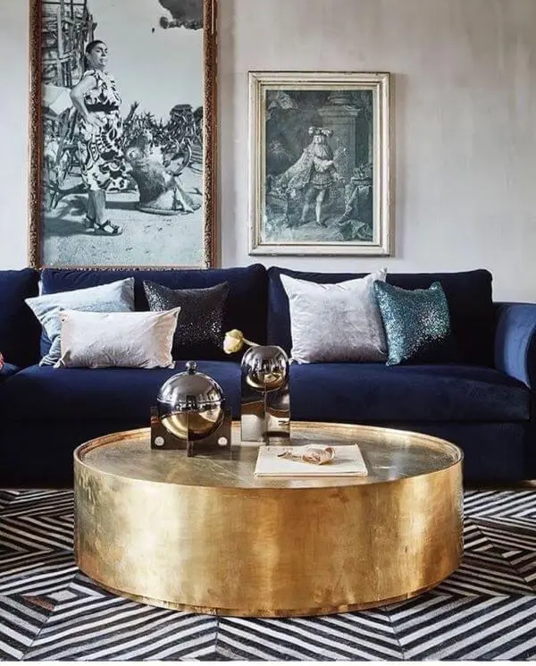 Sofá azul marinho com mesa de centro dourada
