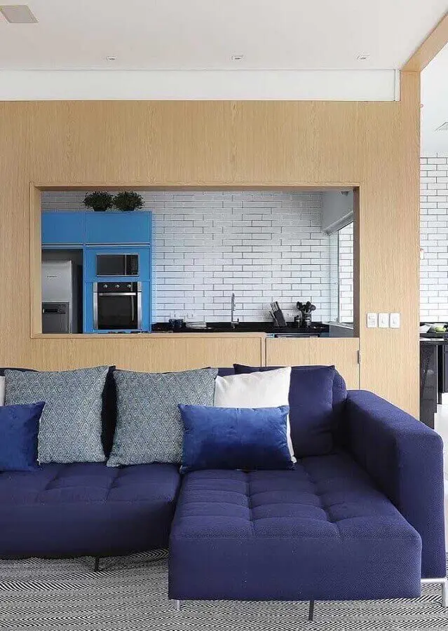 Sofá azul marinho na sala cinza e moderna