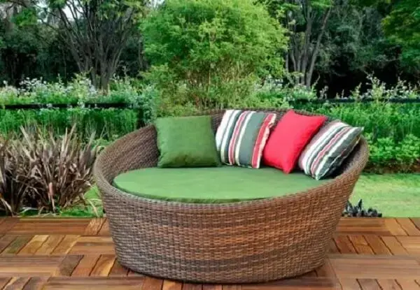 Sofá de vime redondo com almofadas coloridas alegram a área externa