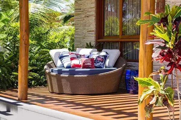 Sofá redondo de vime conhecido como chaise decora o terraço