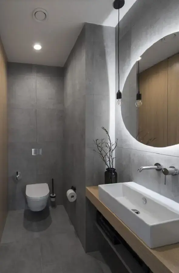banheiro de cimento queimado moderno decorado com espelho redondo com fita de LED Foto Histórias de Casa