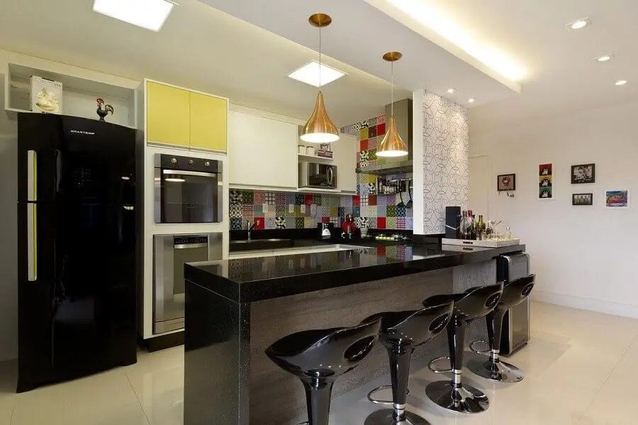 cozinha americana com balcão preto decorada com revestimento colorido Foto Juliana Conforto Interiores