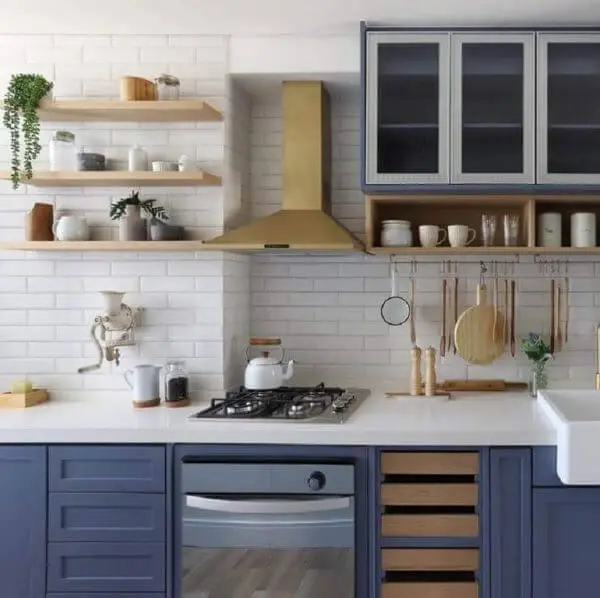 Cozinha com armários azuis e prateleira de madeira