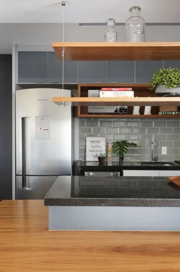 decoração de cozinha planejada com prateleiras de madeira e revestimento metro cinza Foto Jeito de Casa