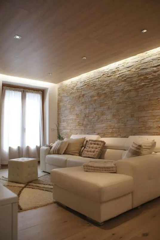 decoração em cores neutras com almofadas para sala com parede rústica Foto Homify