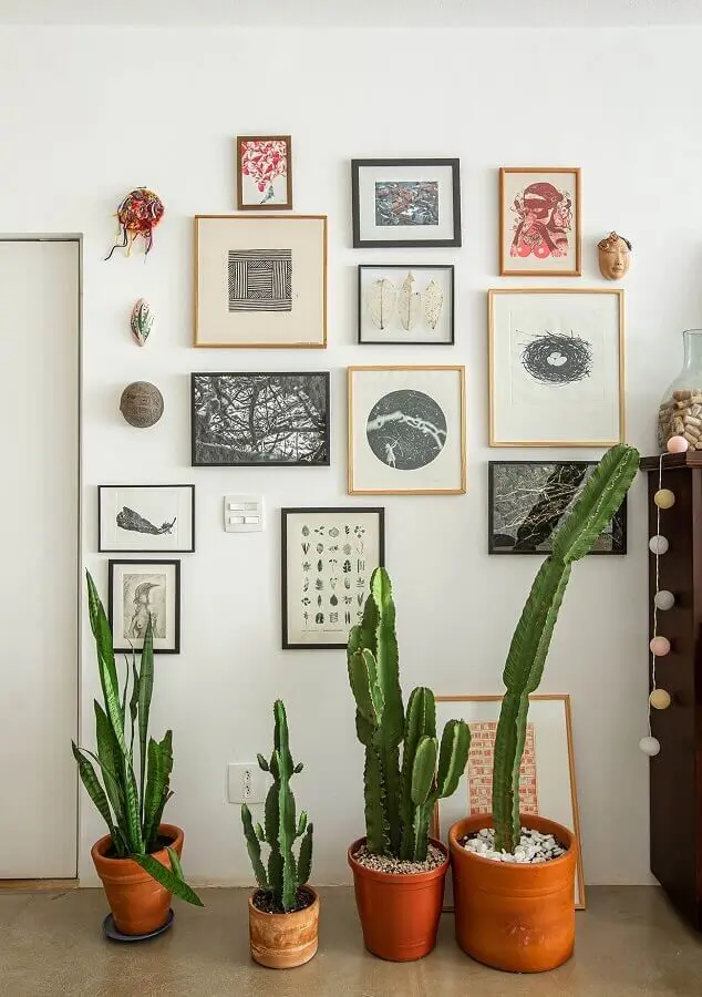 decoração simples com vasos de plantas e parede com quadros Foto Histórias de Casa