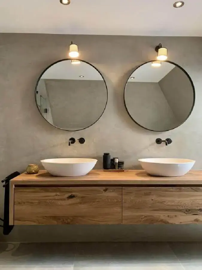 gabinete suspenso de madeira para decoração de banheiro com parede de cimento queimado e espelho redondo Foto Lifs Interior Design