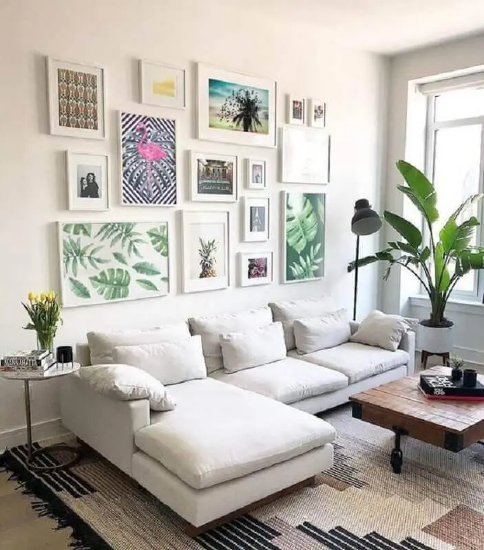 parede com quadros para sala branca decorada com sofá com chaise Foto Jeito de Casa