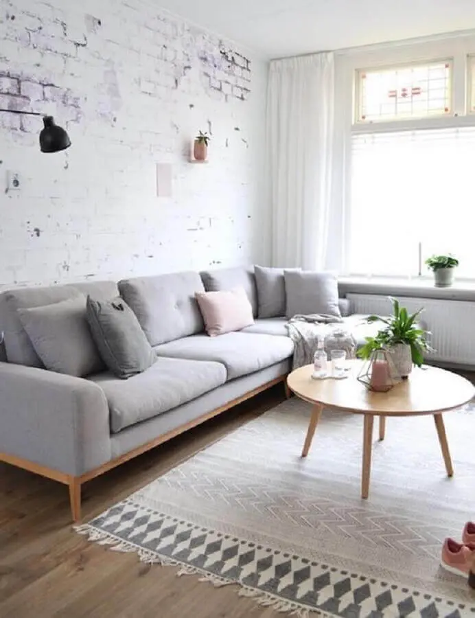 sala minimalista decorada com sofá cinza claro e mesa de centro redonda de madeira Foto Casa de Valentina