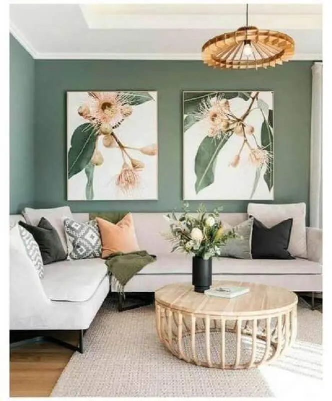 sala verde decorada com sofá de canto e mesa de centro redonda de madeira Foto Jeito de Casa