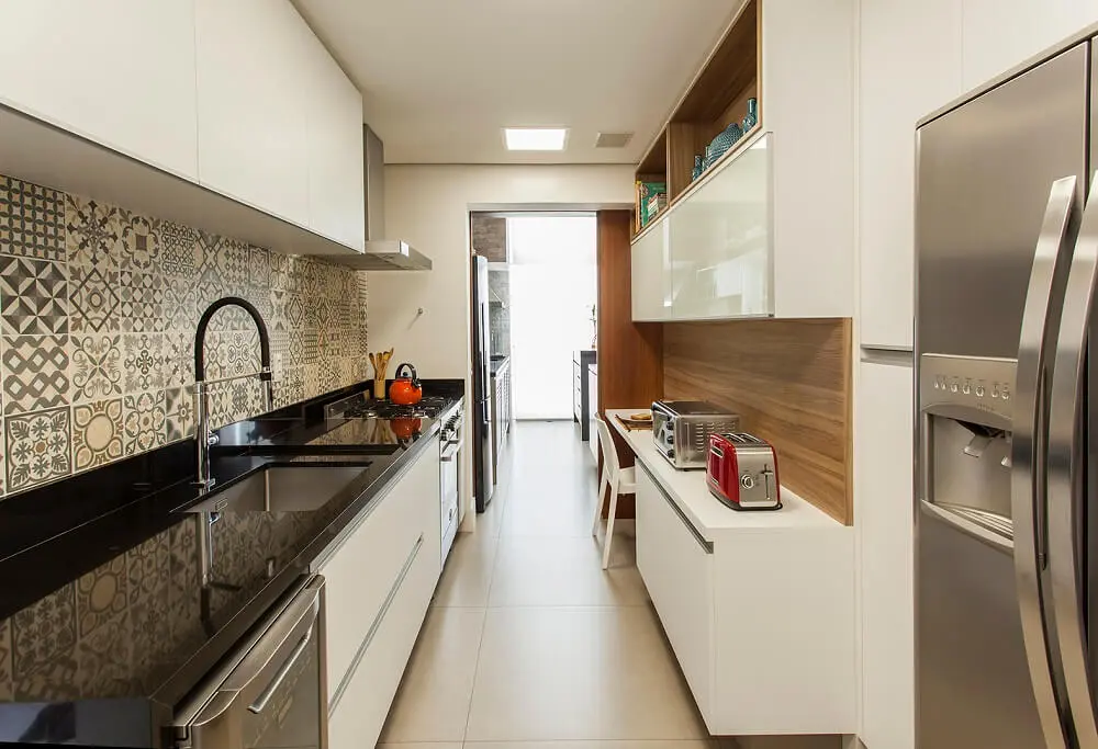 Os armários brancos da cozinha se harmonizam facilmente com os ladrilhos hidráulicos. Foto: Eduardo Pozella
