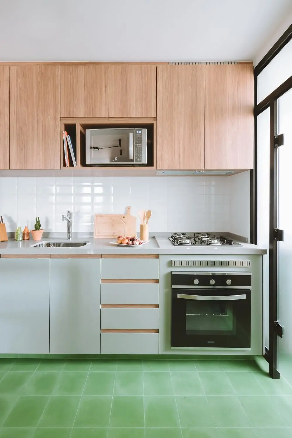 A cozinha foi repaginada e recebeu ladrilho hidráulico na cor verde. Foto: Juliana Deeke