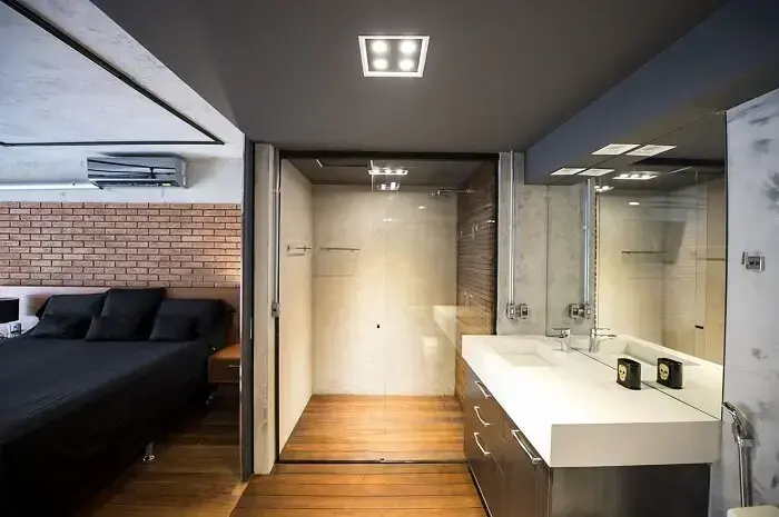 A porta para banheiro suíte de correr é perfeita para áreas pequenas. Projeto por Carla Cuono Arquitetura e Interiores
