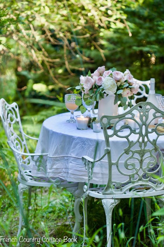 Jardim com mesa de ferro redonda branca