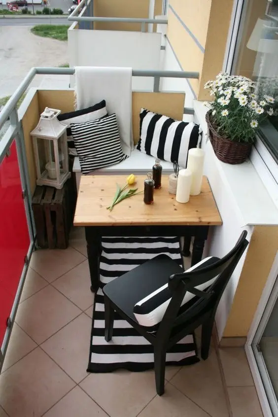 Mesa para sacada pequena com almofadas e decoração charmosa
