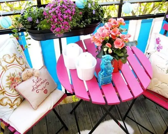 Mesa para sacada rosa e pequena com decoração de flores