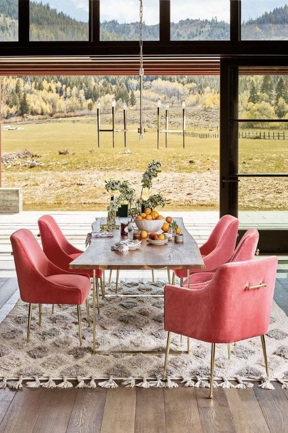 Sala de jantar com mesa de ferro e cadeiras cor de rosa