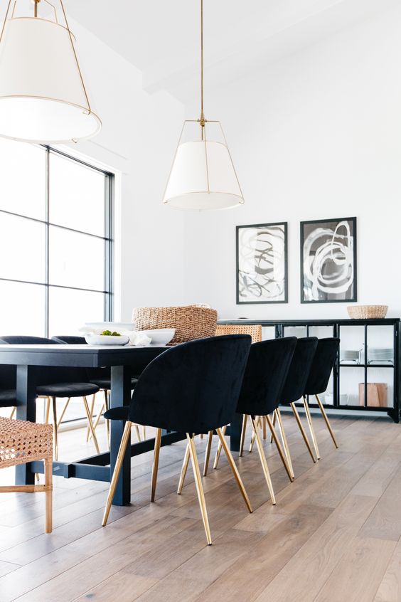 Sala de jantar com mesa de ferro e madeira e cadeiras pretas de luxo 