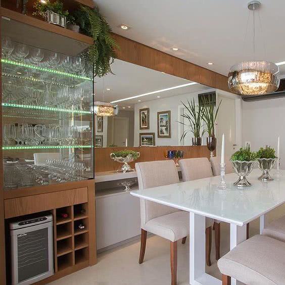 Sala de jantar planejada com cristaleira de parede de vidro adega de madeira e buffet 
