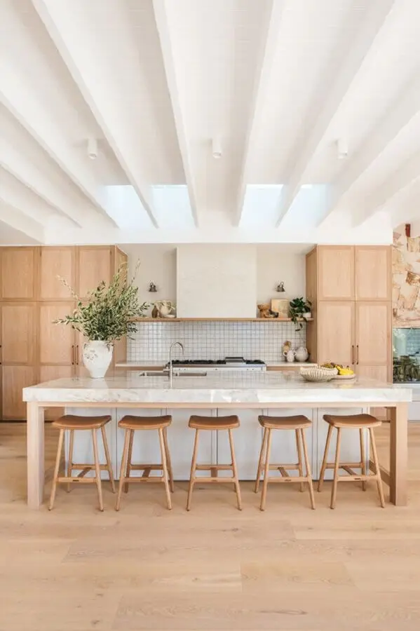 banquetas para ilha de cozinha grande decorada com armários de madeira Foto House & Home