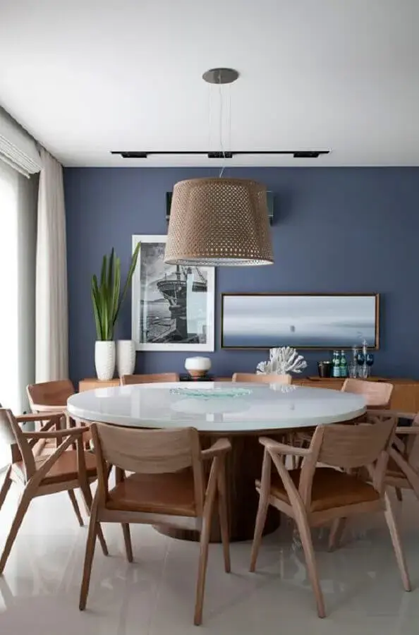 cadeira com braço de madeira para decoração de sala de jantar com mesa redonda e parede azul Foto Juliana Pippi