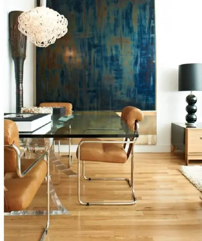 cadeira estofada com braço para sala de jantar decorada com mesa de vidro e quadro grande Foto Pinterest