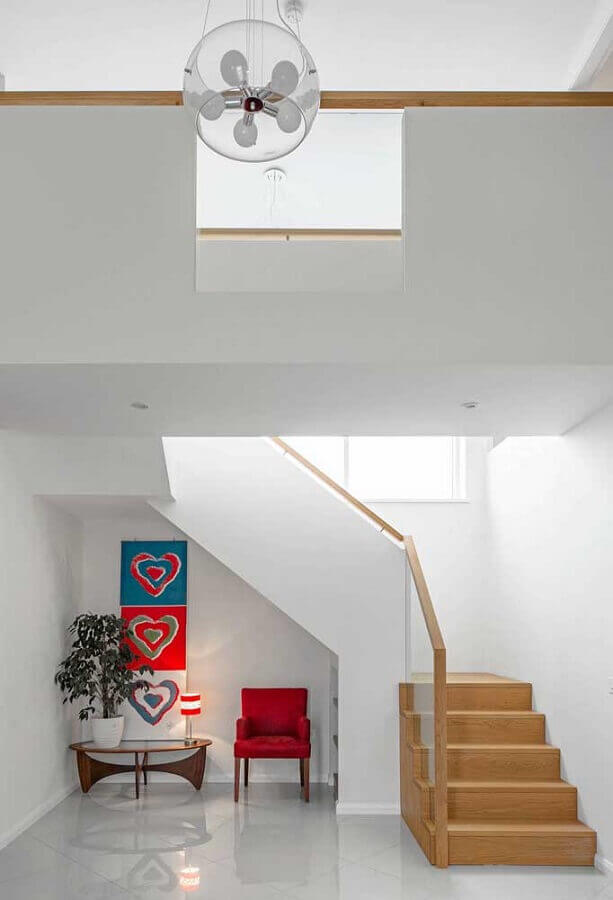 decoração clean com poltrona pequena vermelha embaixo da escada Foto Pinterest